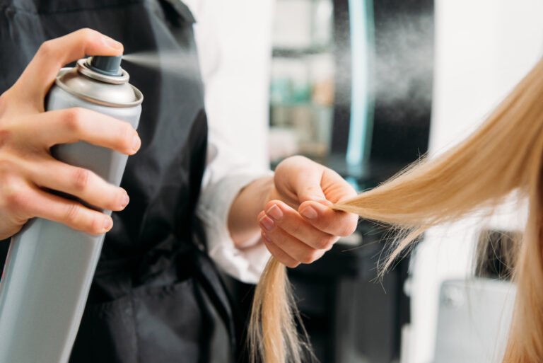 Hair Stylist Using Hairspray on Blonde Hair